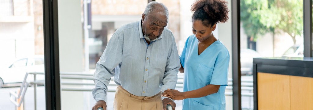 Elderly man assisted by nurse.